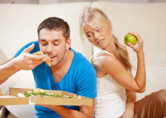 15452167 – bright picture of couple eating different food  focus on man