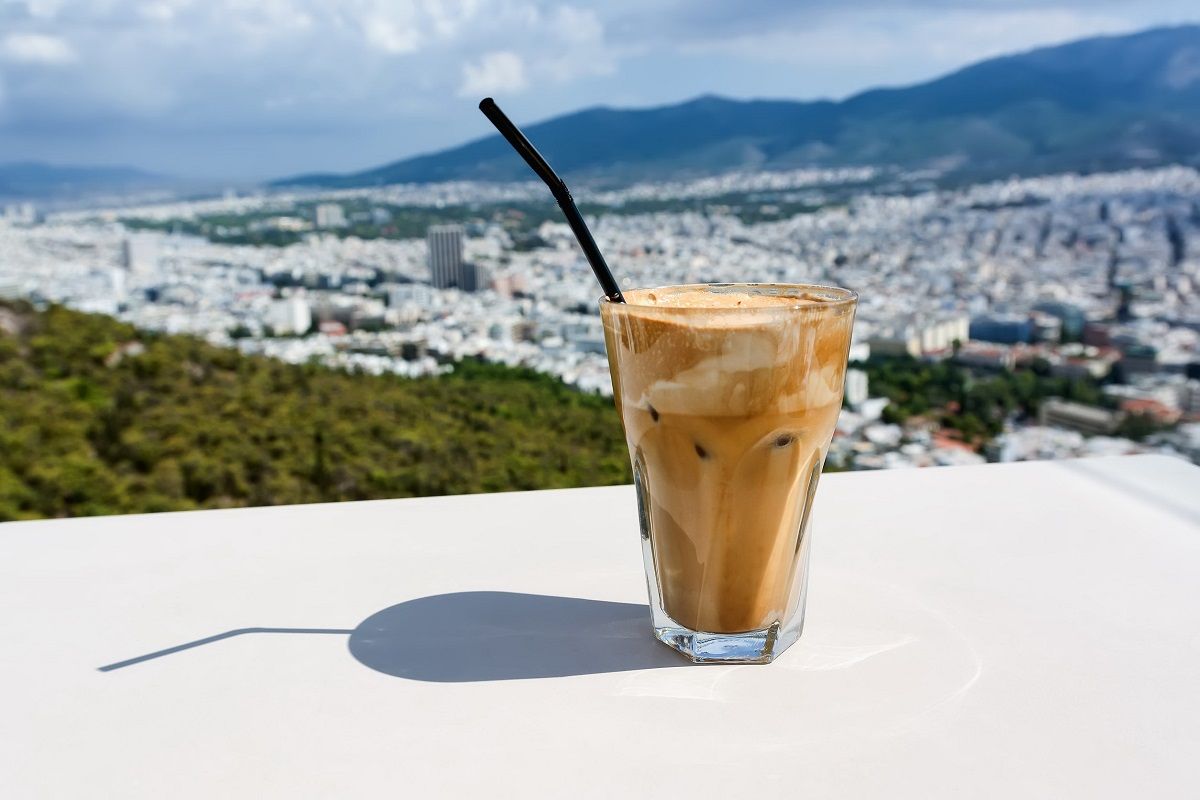91187223 – ice frappe coffee and view of town of athens for background.