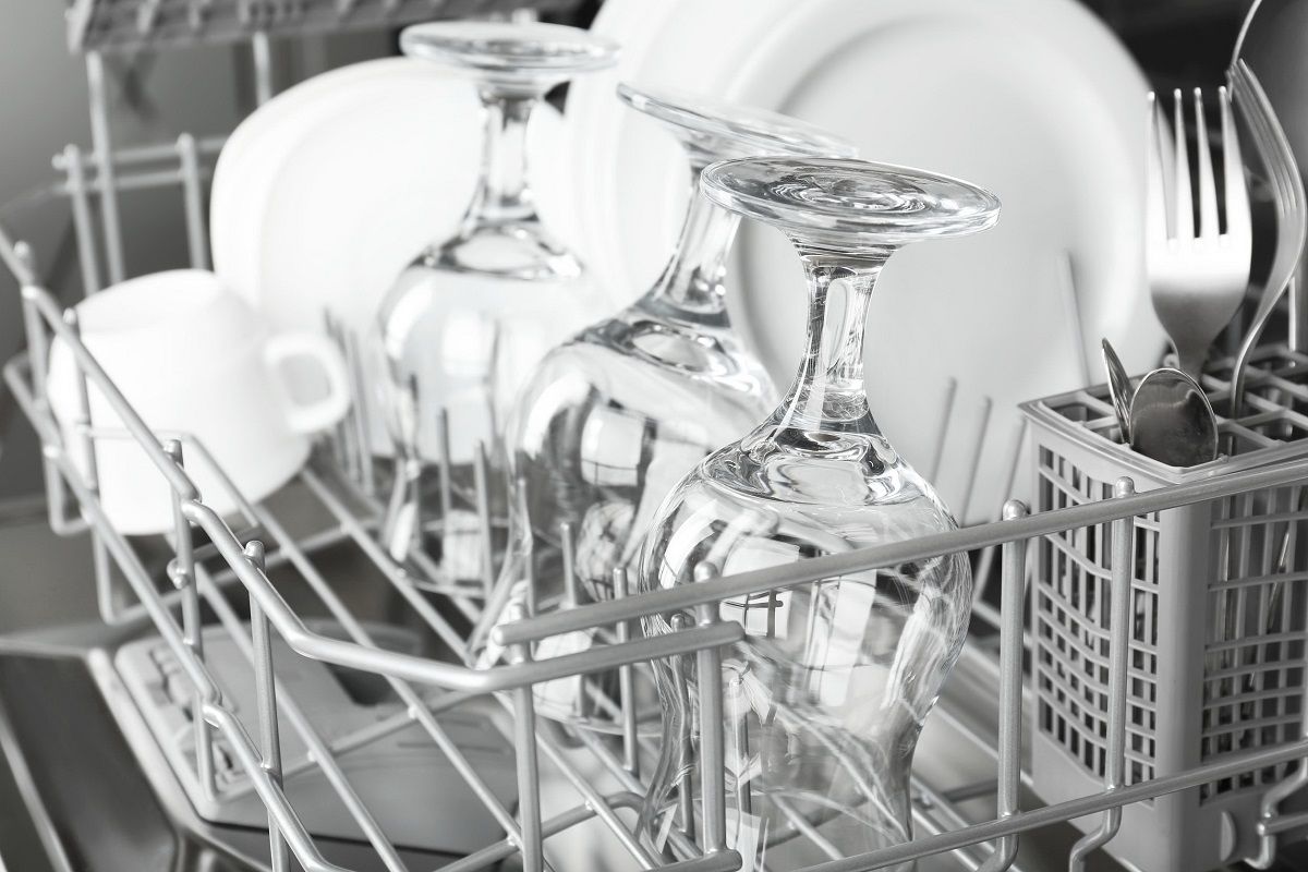 32791998 – open dishwasher with clean utensils in it