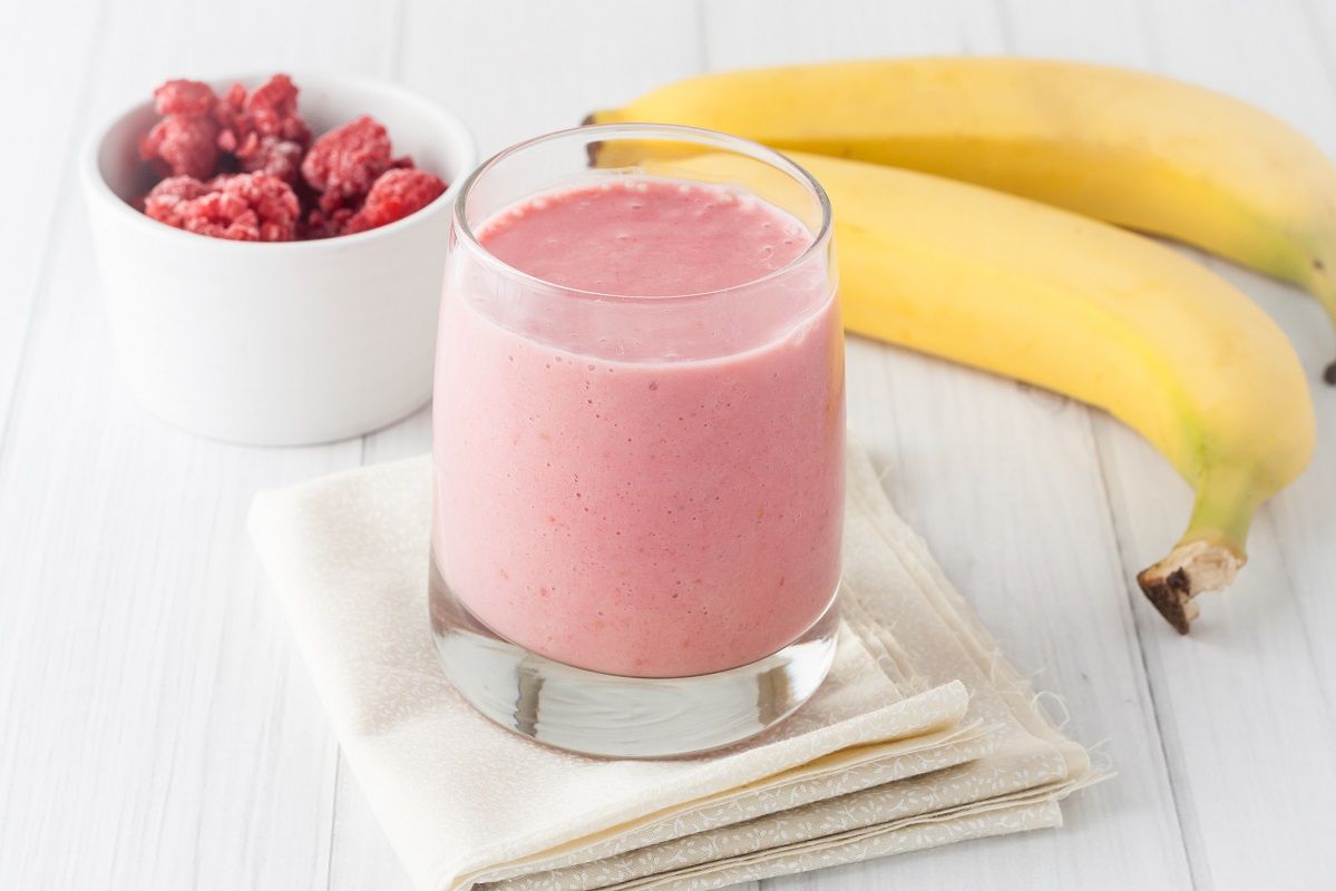 a glass of fresh homemade frozen raspberries and banana smoothie