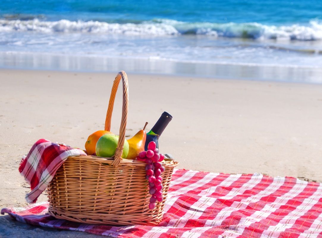 Picnic basket with fruits by the ocean