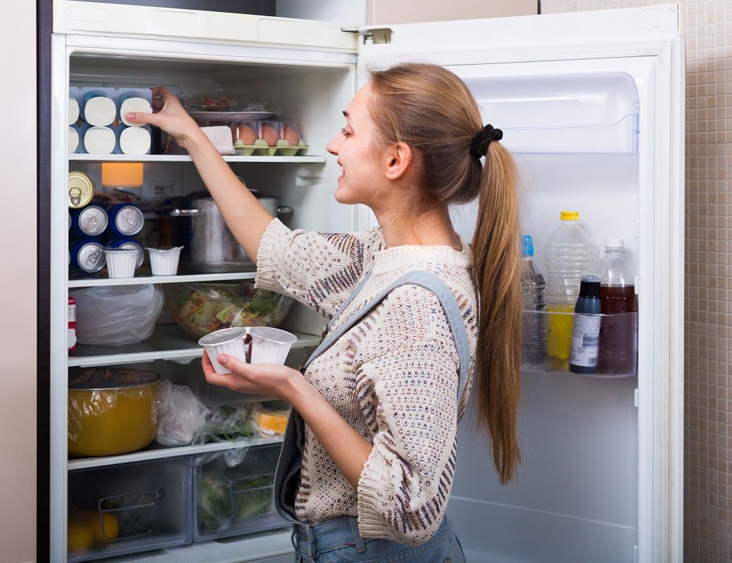 Housewife arranging products in fridge