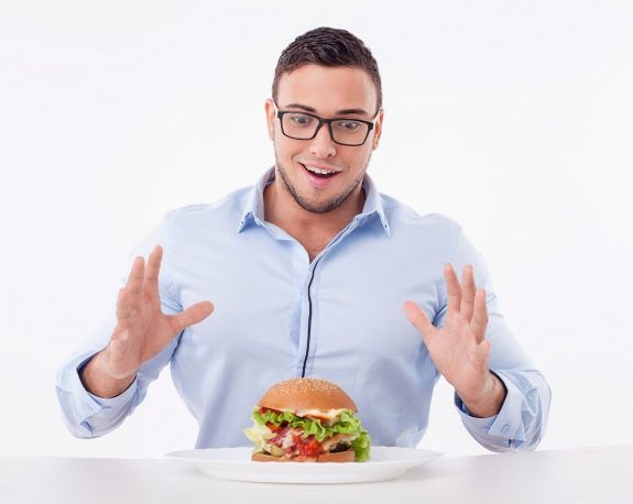 Cheerful young fit man is very hungry