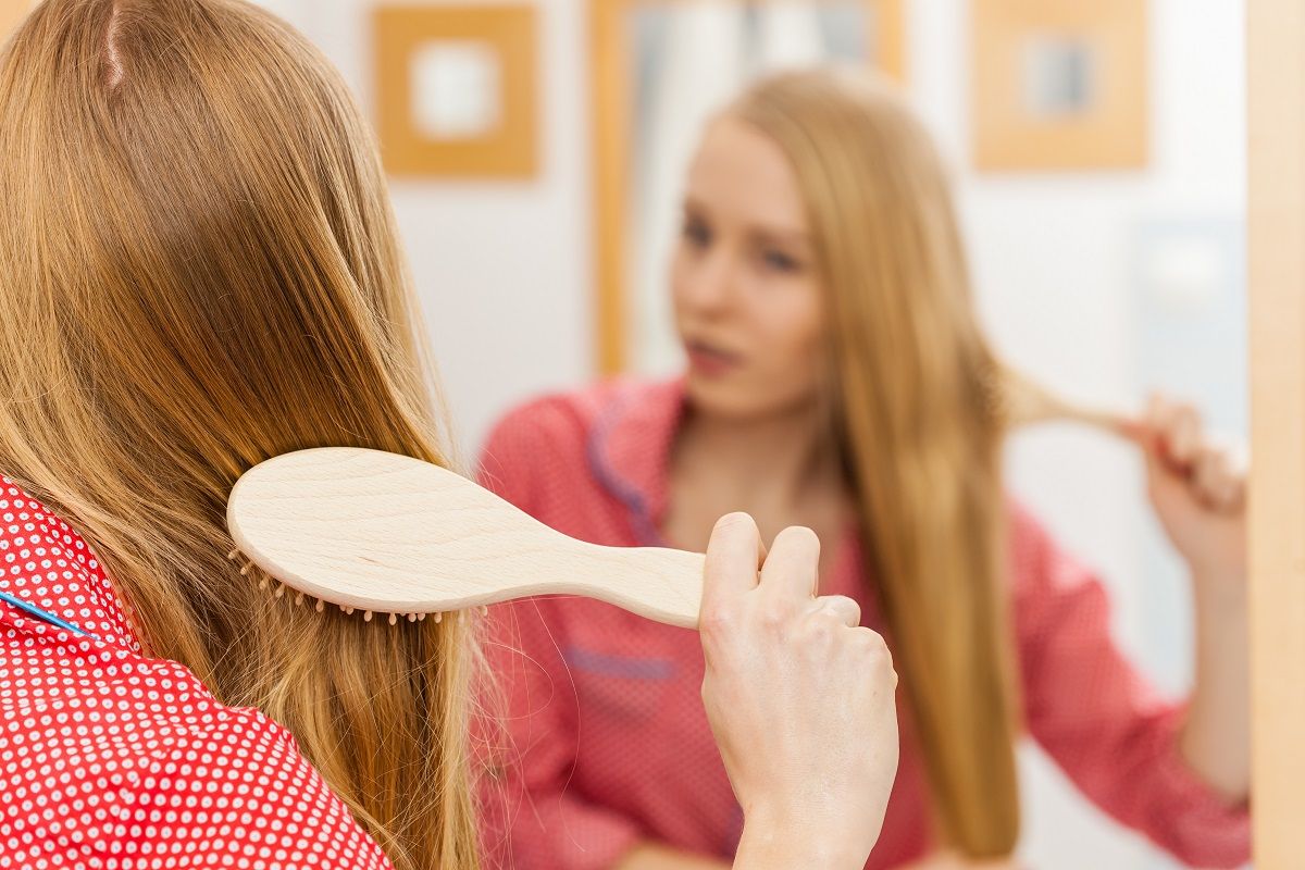 Woman brushing her long hair in bathroom