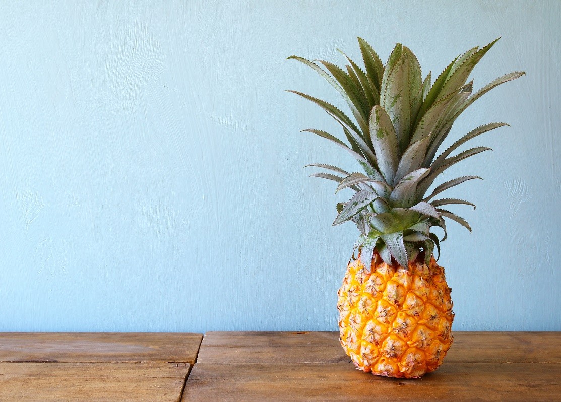 Pineapple on wooden table. Beach and tropical theme