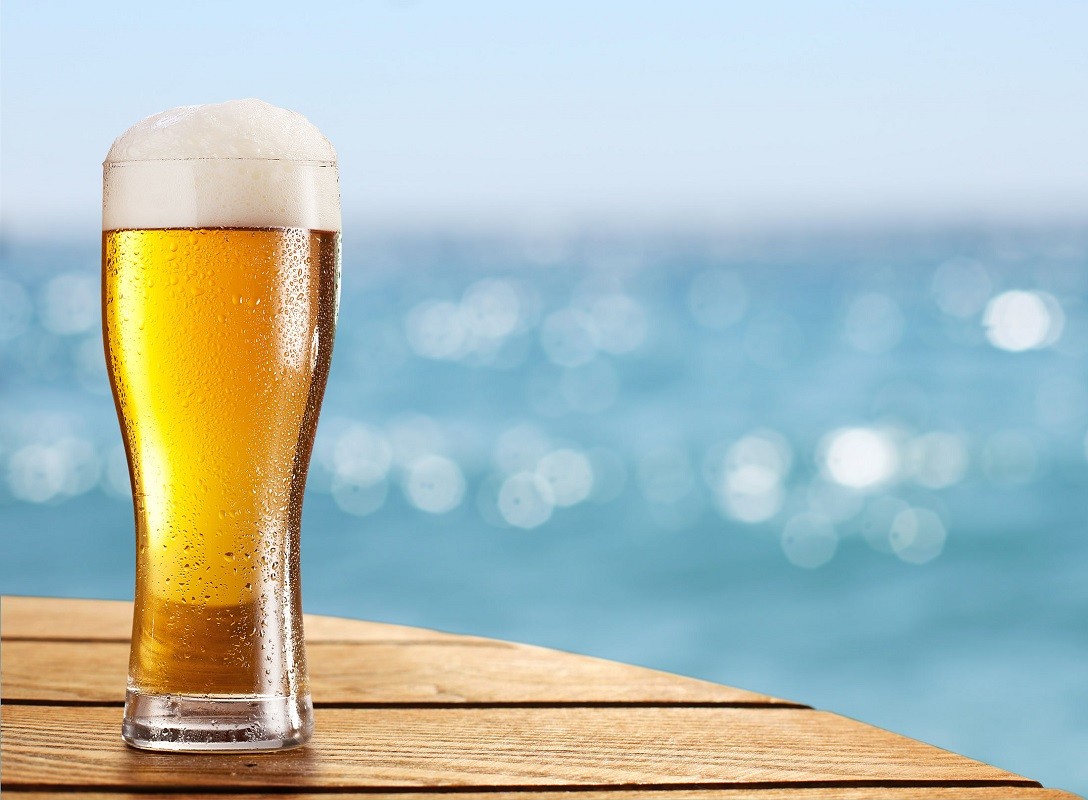 30397061 – beer glass on a blurred background of the sea.
