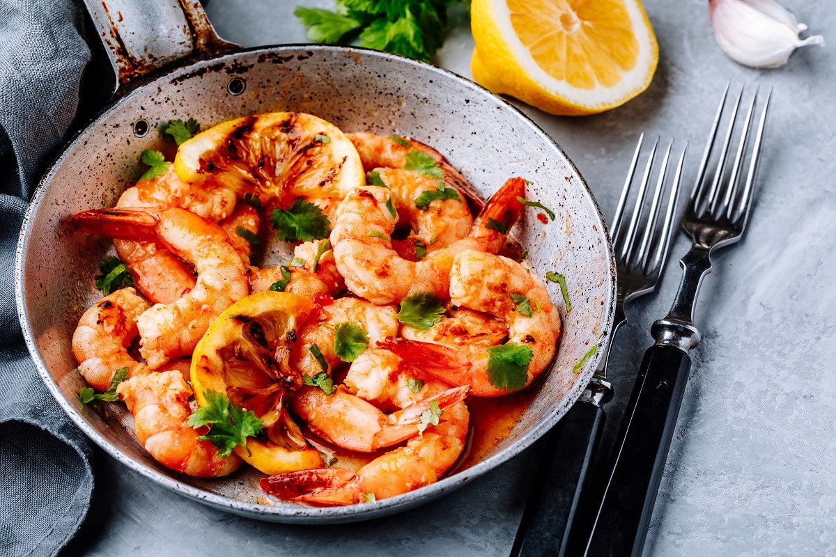 Spicy garlic chilli Shrimps on frying pan with lemon and cilantro