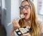 Hungry young woman eating takeaway sushi