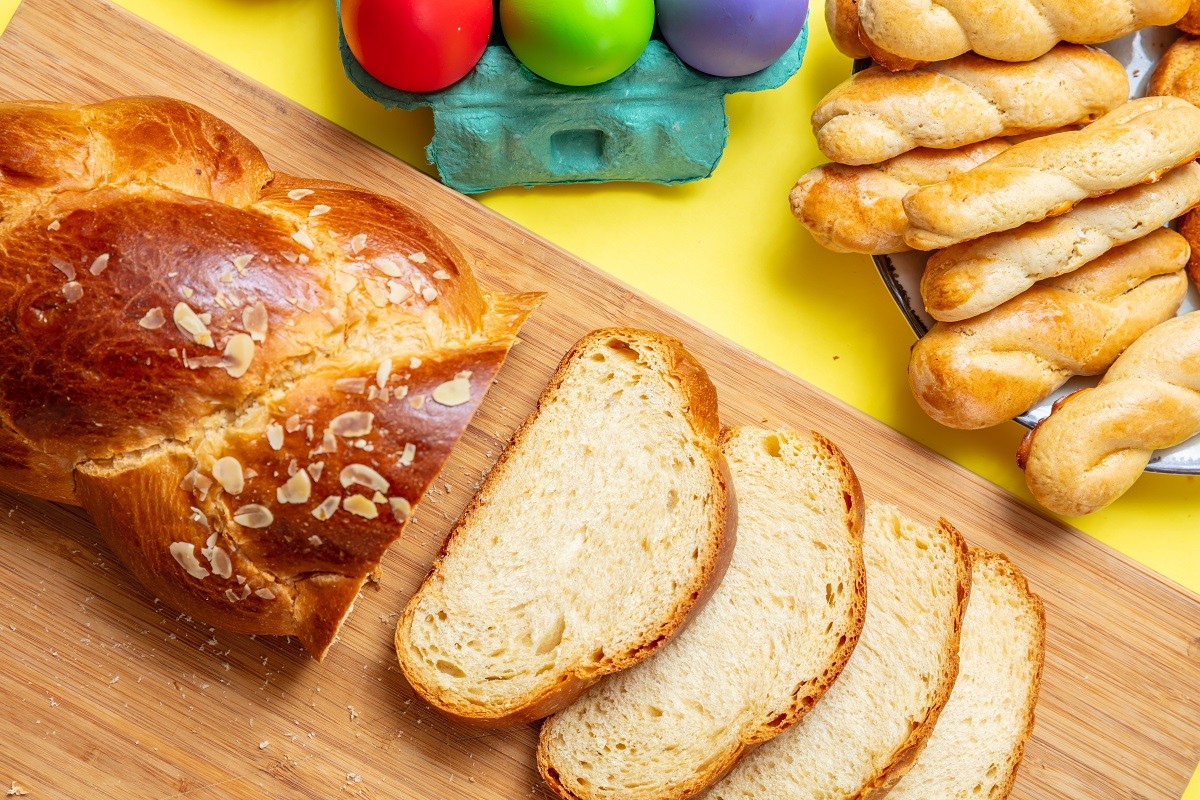 Easter eggs and tsoureki braid, greek easter sweet bread, on wood
