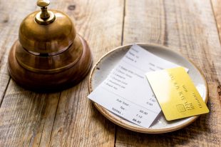 restaurant bill paying by credit card and ring on wooden table background