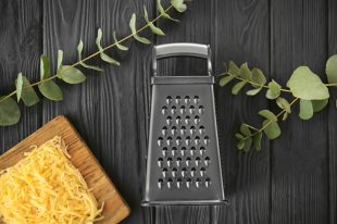 Grater and cheese on  wooden table