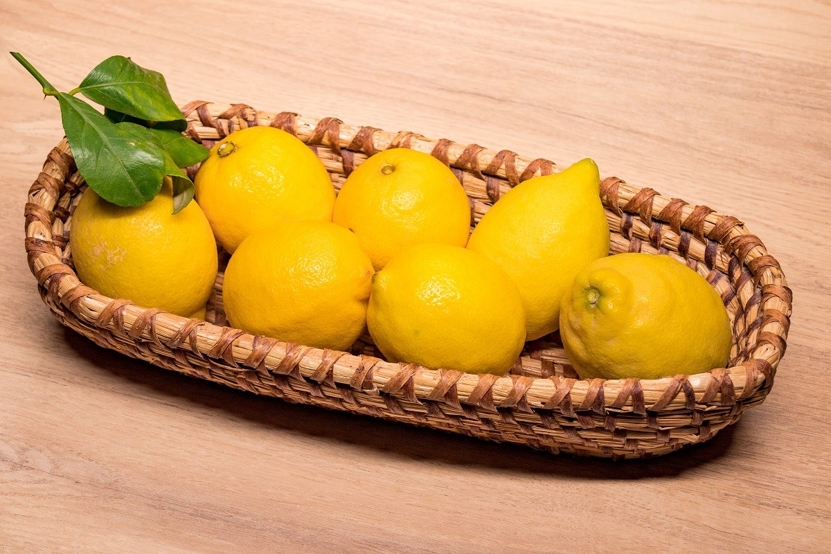 yellow lemons in a small wooden basket