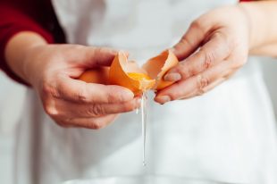 66419093 – woman separating the yolk from the egg white in closeup