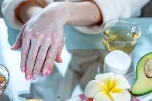 Woman applying the cream on hands nourishing them with natural cosmetics. Concept of hygiene and care for the skin