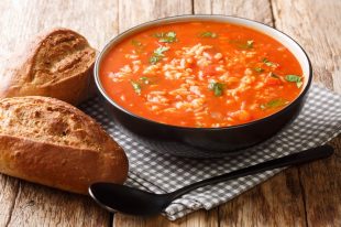 Hearty tomato soup with rice and vegetables close-up in a bowl.