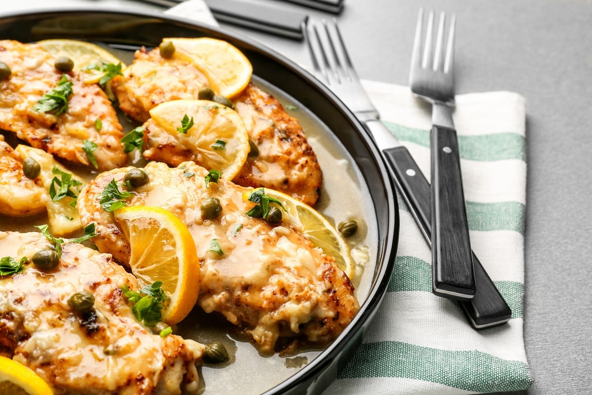 Delicious chicken piccata with sauce and lemon on plate