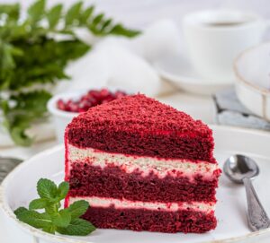 Cake Red velvet on two white plates, two servings. On a light background. Birthday, holidays, sweets.