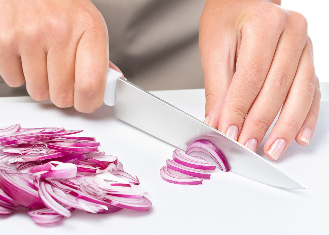 Cook is chopping onion