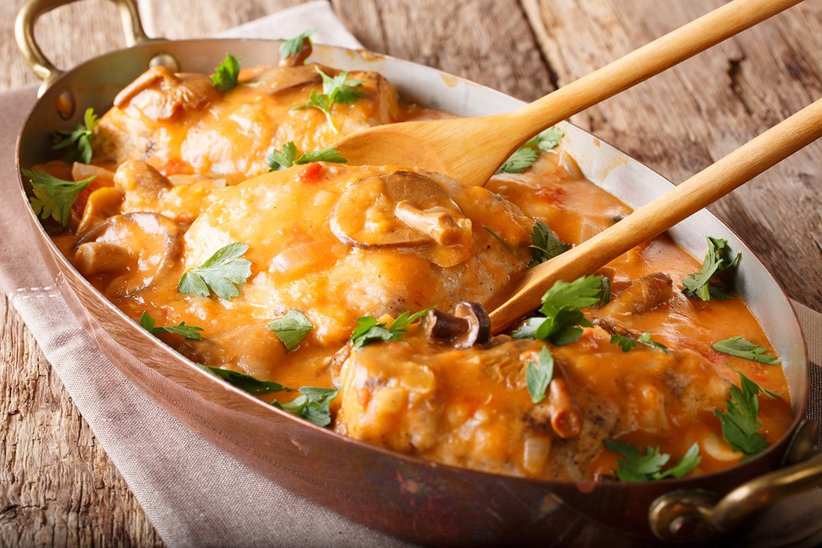 Home French chicken chasseur with mushrooms and tomatoes close-u