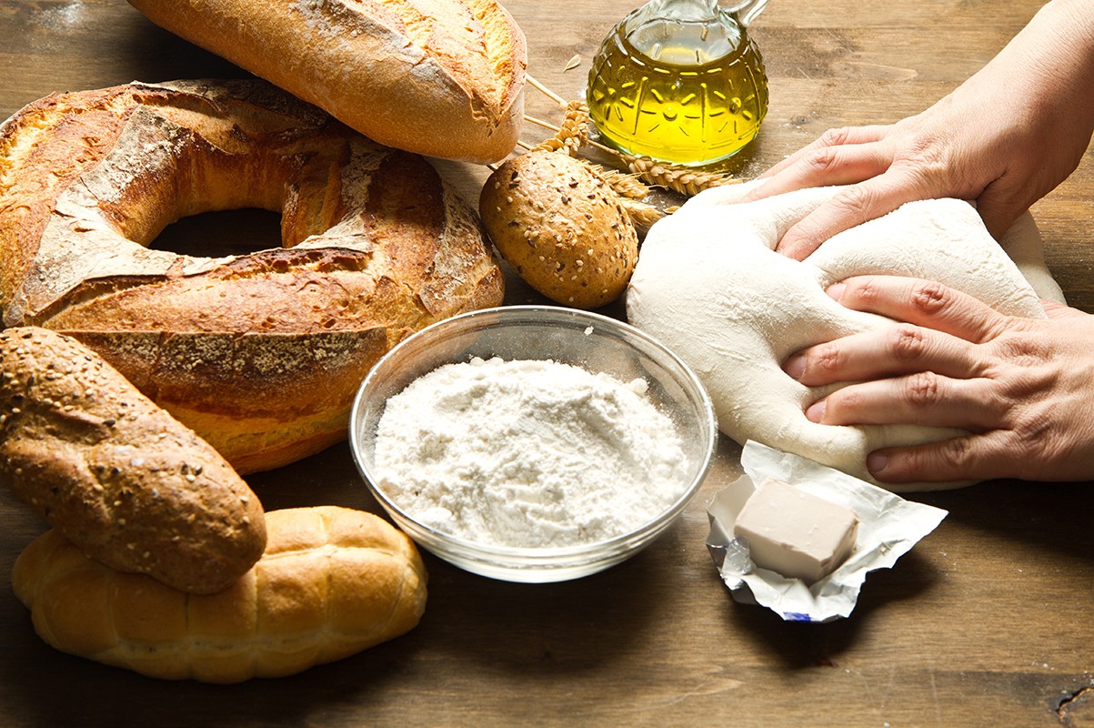 18669693 – female hands in flour closeup kneading dough on table