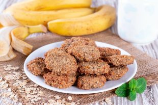 Homemade oatmeal cookies with banana, oats on a wooden background. Healthy breakfast concept.