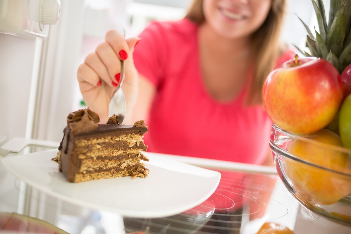 Tasty piece of chocolate cake attracts girl to eat it