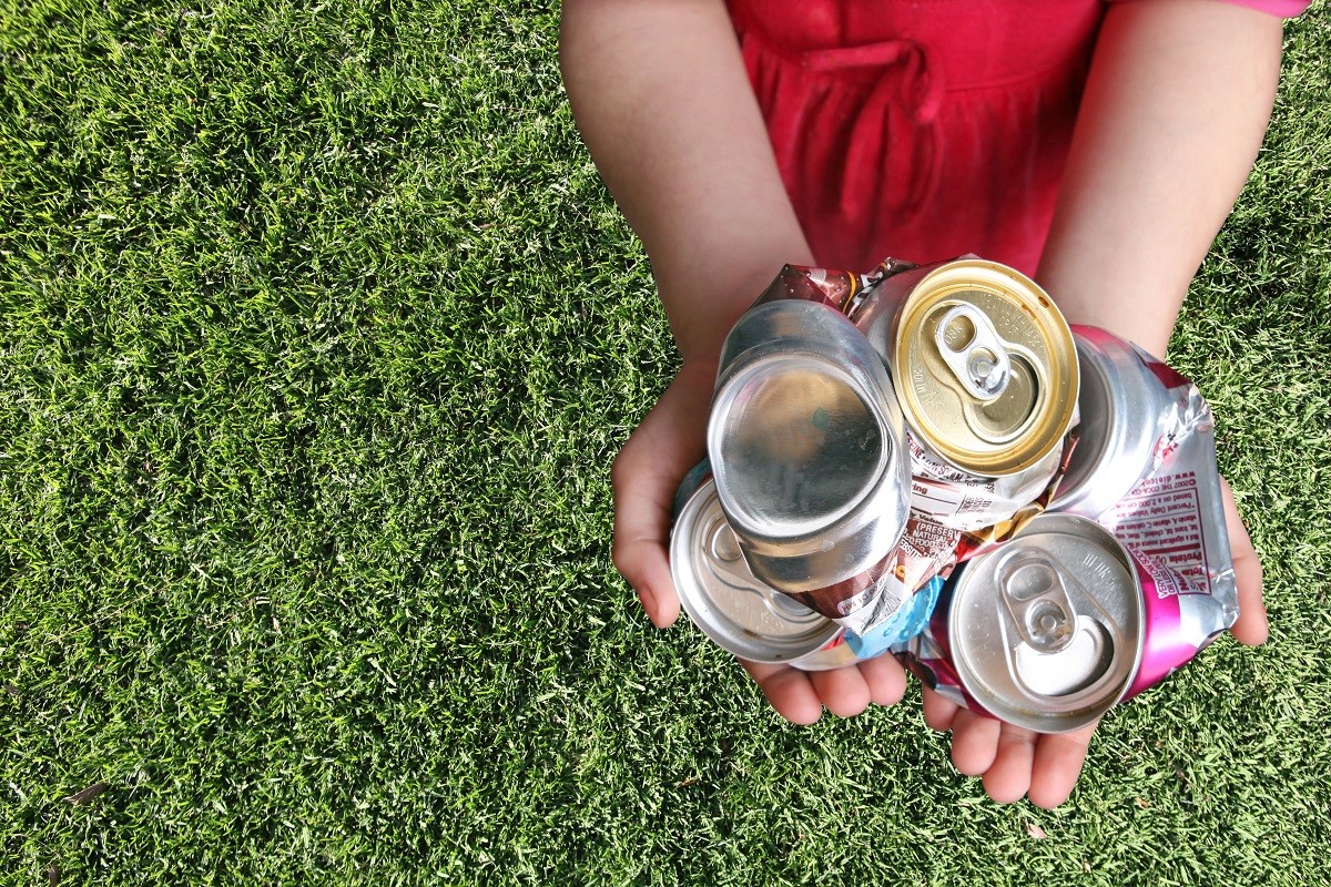 Aluminum Cans Crushed For Recycling in a Childs Hands