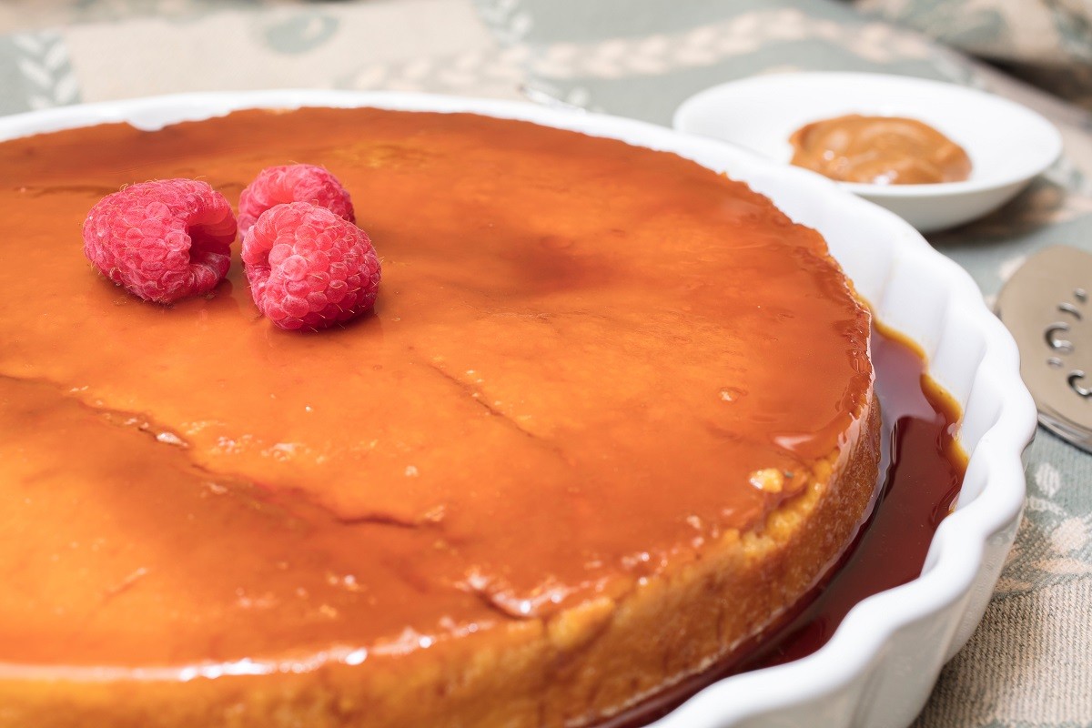 Creamy Flan dessert served  with raspberries and dulce de leche