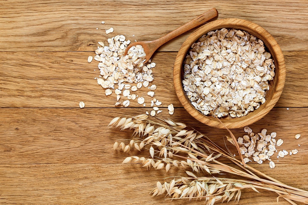 Rolled oats and oat ears of grain on a wooden table