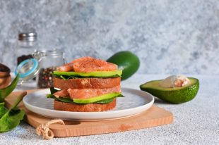 Rye bread sandwich with avocado and salmon. Horizontal.
