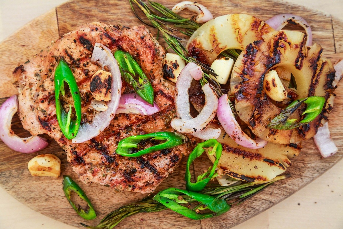Grilled pork with pineapple, red onion and hot green pepper. Serve on a wooden board.