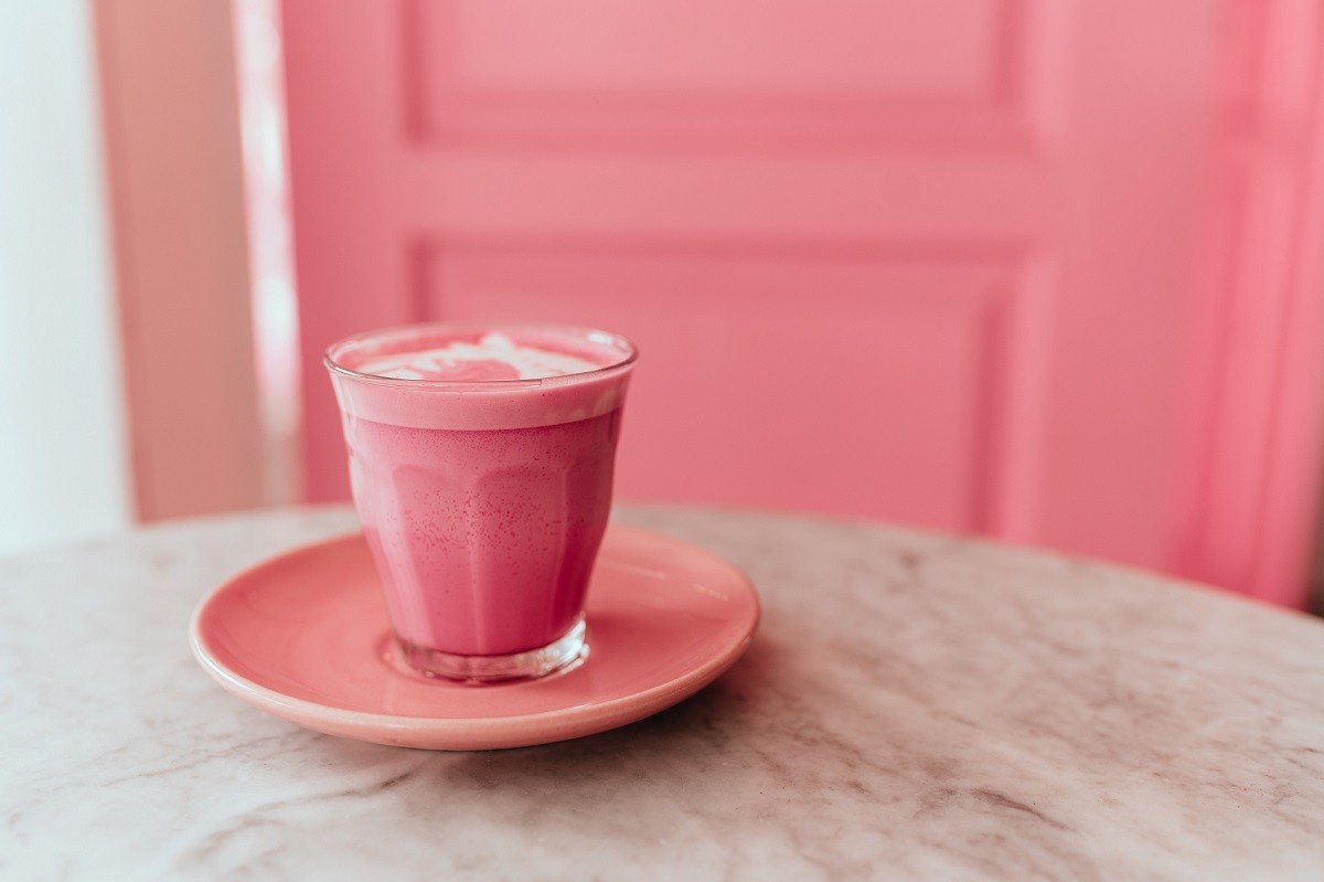trendy beetroot latte with latte art and flower petals