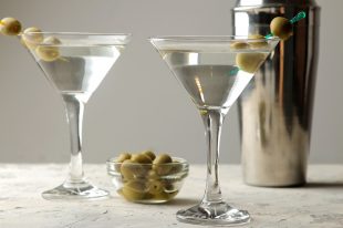 Martini. Alcoholic drink martini with olives in a glass on a light background in the bar on the bar counter. bar inventory. cocktails