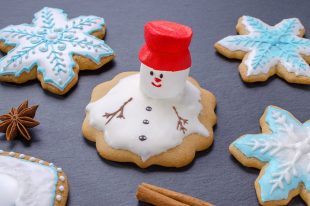 handmade christmas cookies, melted snowman with red hut and snowflake gingerbread