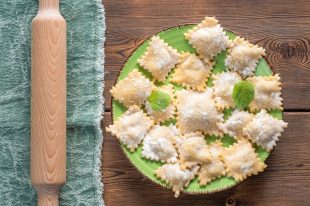 Top View of Fresh Homemade Ravioli on Wooden Background With Rolling Pin