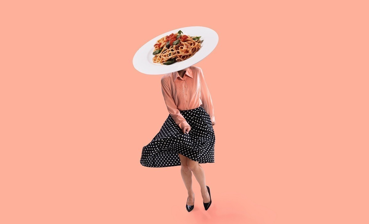Contemporary art collage. Young girl in attire of 70s, 80s fashion style with plate of noodles instead head dancing isolated on pink background