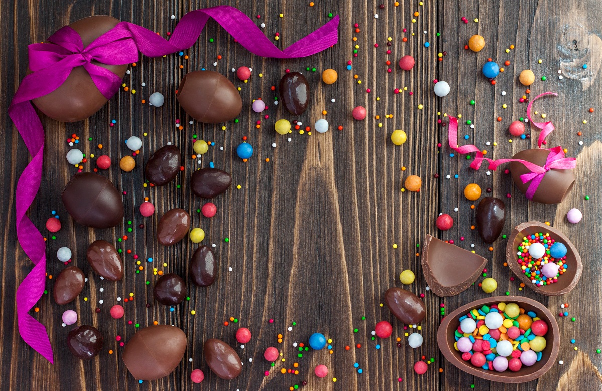 Chocolate Easter eggs over rustic wooden background. Copy space