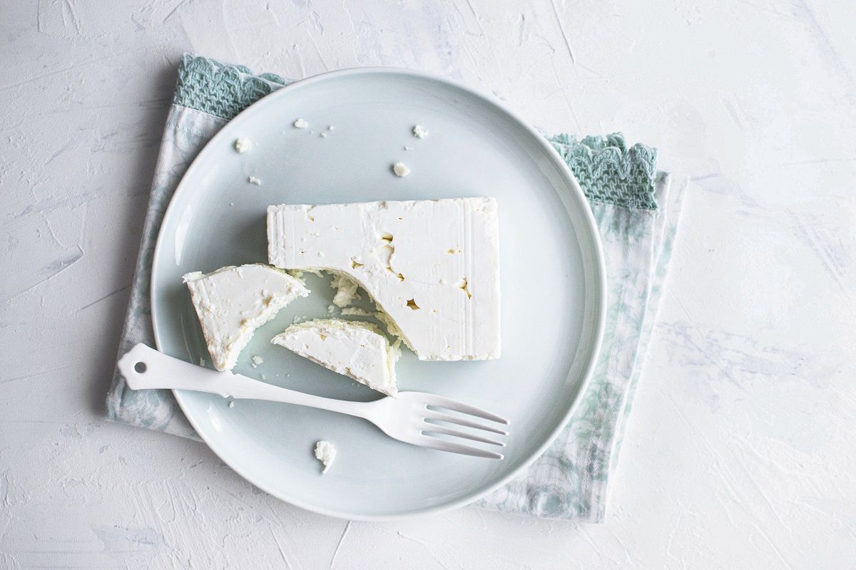 Feta cheese on a  white plate with fork flat lay