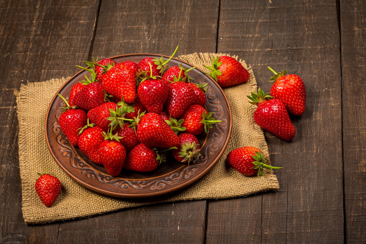 Ripe red strawberries on a brown wooden background