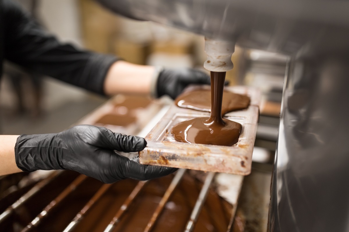 confectioner makes chocolate candies at sweet-shop