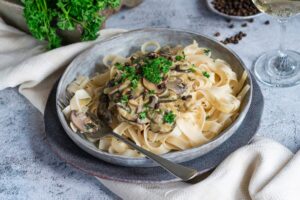 Pasta tagliatelle and mushrooms in creamy sauce with brandy and peppercorns