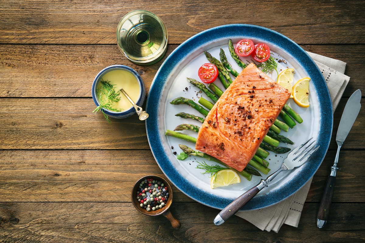 Grilled salmon garnished with green asparagus and tomatoes