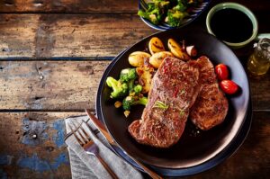Steak, potato and vegetable dinner on table
