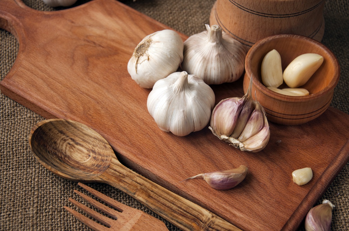 Garlic on cutting board , close-up on sacking. burlap background