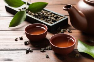 Cups and teapot of Tie Guan Yin oolong on wooden table
