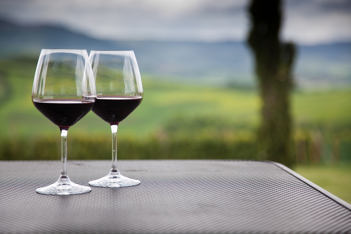 Two,Glasses,Of,Red,Wine,Against,Beautiful,Landscape,In,Tuscany