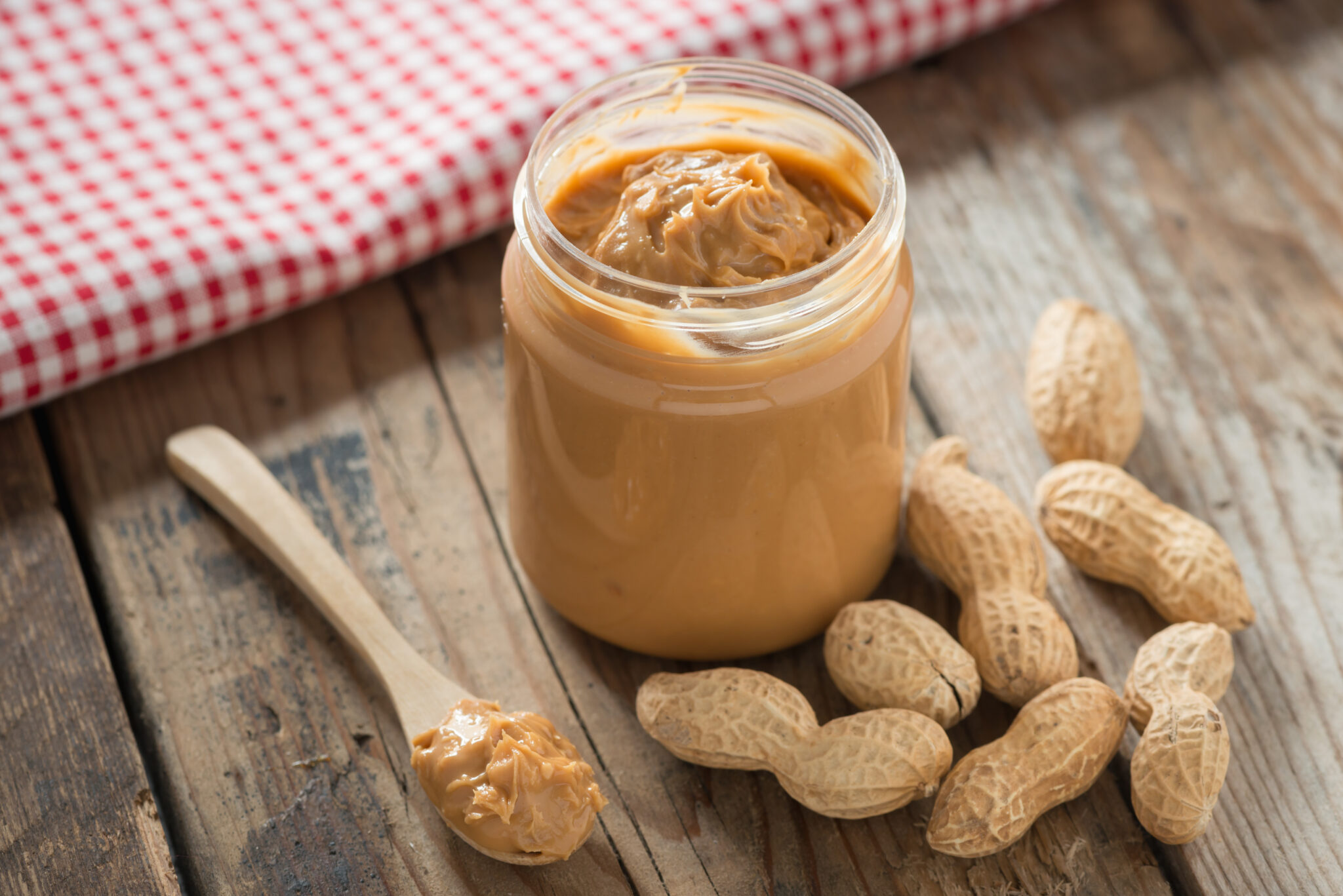 Creamy,And,Smooth,Peanut,Butter,In,Jar,On,Wood,Table.