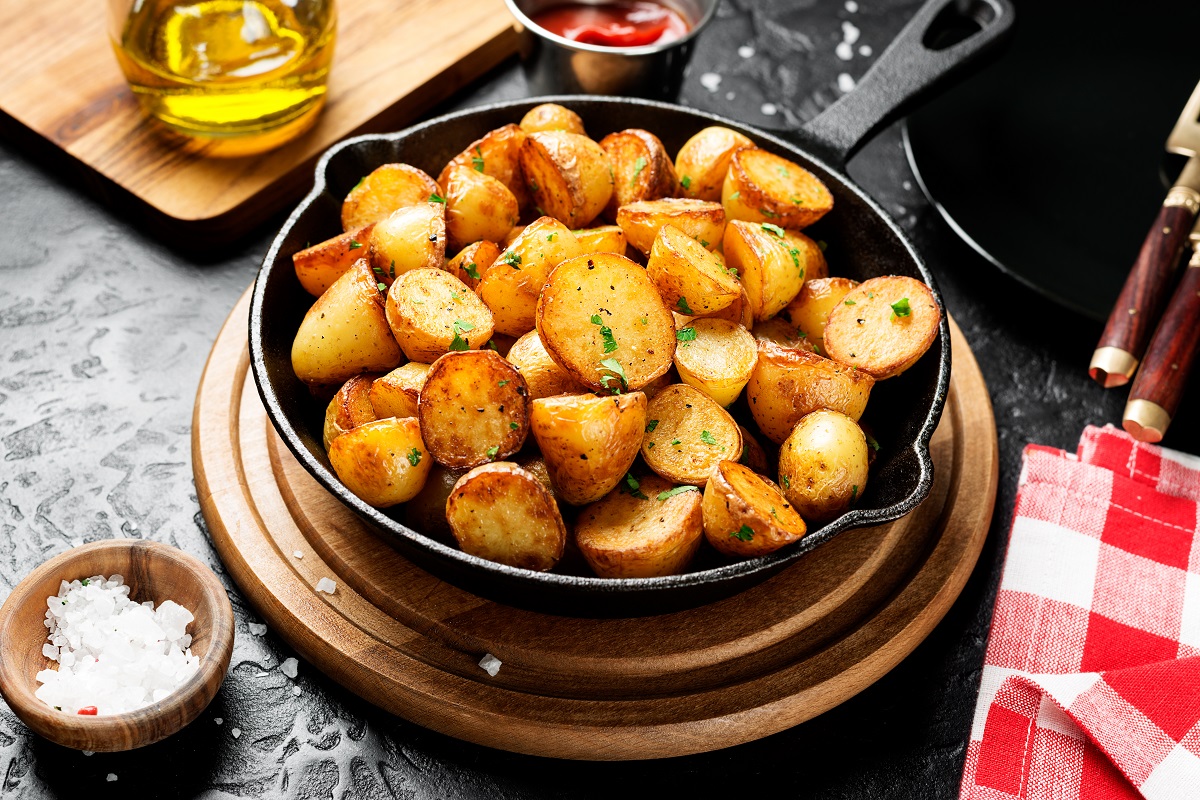 Roasted,Baby,Potatoes,In,Iron,Skillet,On,Black,Background.