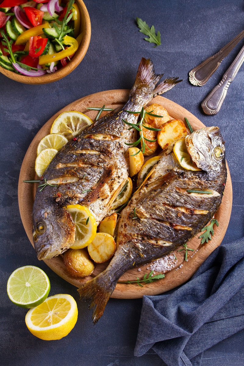 Grilled,Fish,With,Roasted,Potatoes,,Lemon,And,Rosemary,On,Wooden