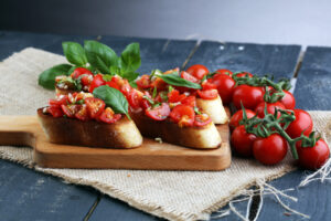 Bruschetta,,On,Slices,Of,Toasted,Baguette,Garnished,With,Basil